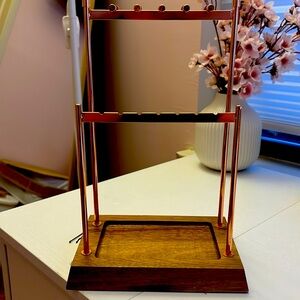 This is a rose gold with wooden bottom jewelry holder